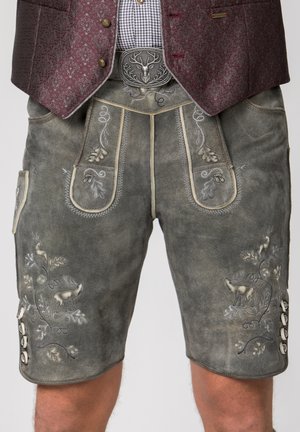 Traditionelle graue Lederhosen mit filigraner Stickerei von Hirsch und Eichenblättern, kombiniert mit karierter Hemd, kastanienfarbener Weste und Hirsch-Gürtelschnalle.
