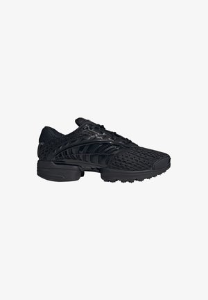 Chaussure de sport noire avec empeigne en mesh, semelle en caoutchouc texturée et superpositions synthétiques brillantes, vue de profil sur fond blanc.