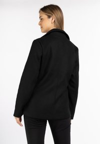 Black wool-blend jacket with a structured design, notch lapels, and tailored fit. Features long sleeves and a straight cut at the back.
