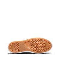 Zool van een Converse All Star sneaker met oranje rubberen profiel in diamant- en lijnpatronen op een witte achtergrond.