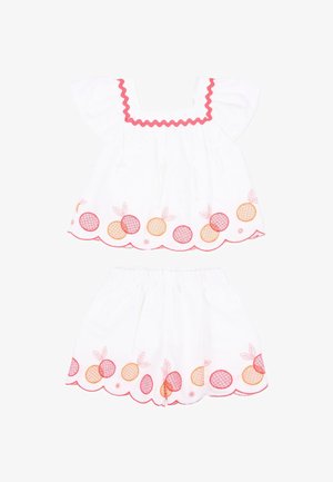 Completo bianco per bambino con maniche a svolazzo e pantaloncini, decorato con frutta ricamata arancione e rossa e bordi smerlati.