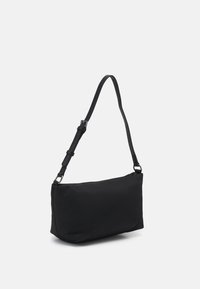 Sac à dos noir en tissu, avec une seule sangle ajustable, de forme rectangulaire et une fermeture supérieure zippée. Texture lisse.
