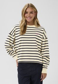 Gestreifter Sweatshirt aus weicher Baumwolle mit gelben und marineblauen Querstreifen. Rundhalsausschnitt, überschnittene Schultern und kleines gesticktes Logo-Detail.