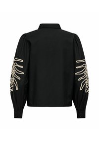 Blouse noire à manches longues avec manches bouffantes et motifs abstraits brodés en lignes blanches sur les bras extérieurs, vue de dos.