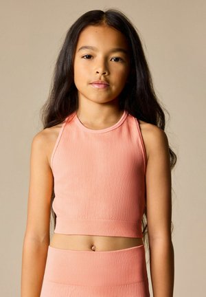  ferskenfarvet ribbet crop top med høj halsudskæring og ærmeløs design. Sømmefri konstruktion og en figursyet silhuet fremhæver formen.