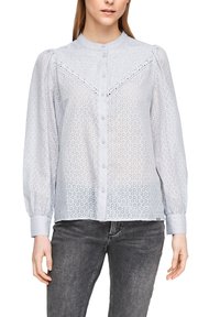 Blusa azzurra chiara con maniche lunghe, chiusura a bottoni, colletto, pannelli in pizzo decorativi e un delicato motivo floreale. Realizzata in tessuto trasparente.
