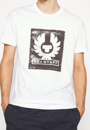 Witte katoenen t-shirt met een zwart grafisch logo met vleugels en de tekst "BELSTAFF" onderaan. Klassieke ronde hals, korte mouwen.
