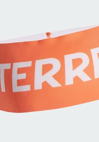 Oranžová látková čelenka s bílým tučným textem. Hladká textura, široký design, s prošitým okrajem a středním elastickým páskem.