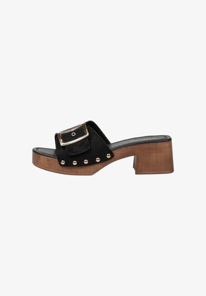 Zueco negro con punta abierta, tacón de bloque de madera, gran hebilla dorada y tachuelas decorativas doradas a lo largo de la correa lateral.