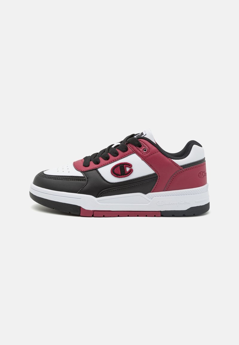 Sneakers z białą skórzaną cholewką, czarnymi akcentami i bordowymi detalami. Czarny sznurówki, wyściełany kołnierz i logo po bokach. Gumowa podeszwa.