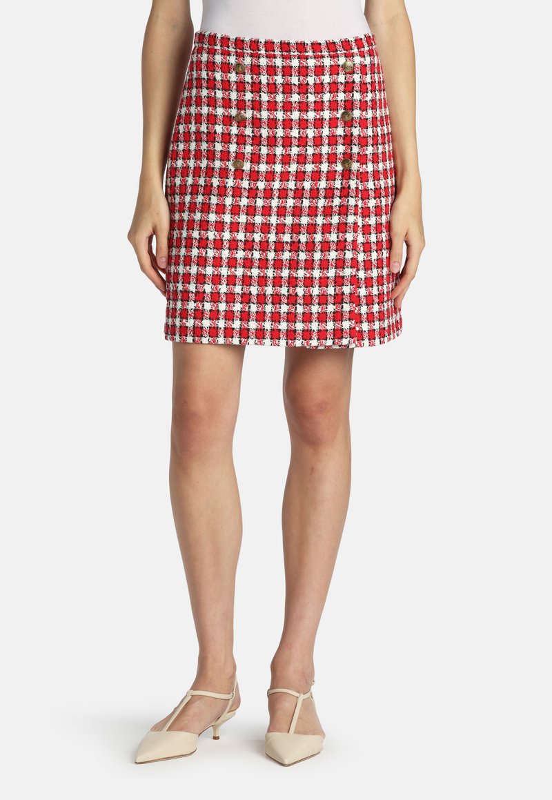 Rød og hvid ternet nederdel med tekstureret finish og knapdetaljer foran, stylet med beige spidse sko.