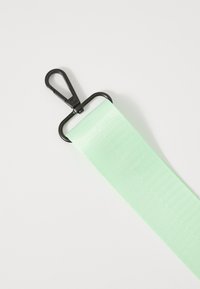 Mentazöld nylon heveder, struktúrált felülettel, fekete fém csatlakozóval. Különféle hordozási célokra alkalmas.
