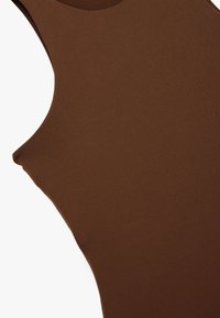 Brązowy bezrękawnik z gładkiego, elastycznego materiału. Posiada okrągły dekolt i dopasowany krój, podkreślający sylwetkę.