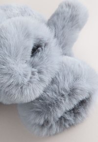 Gray faux fur slippers with a soft, fluffy texture. Round shape with a seamless design and a plush, luxurious appearance.