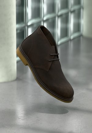 Braune Leder-Stiefeletten mit Schnürdesign, gepolstertem Kragen und Gummisohle. Verfügt über abgestepptes Detail und eine glatte Textur.