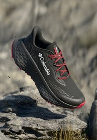 Adidași negri pentru alergare cu un profil texturat, șireturi roșii și accente roz pe talpă. Prezintă un logo pe lateral și un design îmbunătățit cu pernițe.
