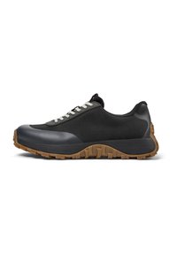 Scarpa sportiva nera con tomaia in mesh testurizzato, punta in gomma, suola grigia e lacci bianchi a contrasto. Presenta un design snello.