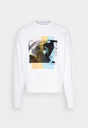 Witte sweatshirt met een grafische print in zwart, geel en blauw, met een ronde halslijn en ribgebreide manchetten. Merktekst weergegeven onder het ontwerp.