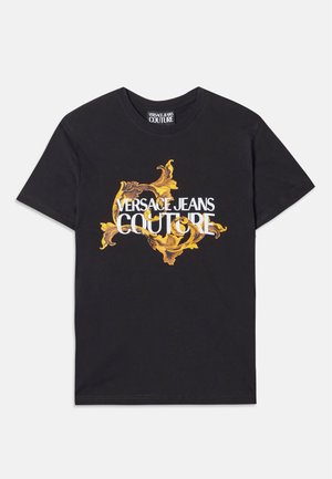 Čierne bavlnené tričko s centrálnou grafikou, na ktorej sú zlaté a žlté ornamentálne vzory a bielym textom, ktorý znie "VERSACE JEANS COUTURE."