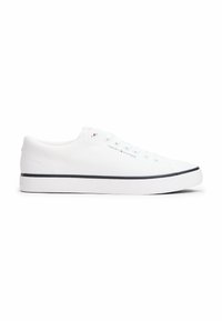 White canvas sneakers with a textured upper, featuring six eyelets, flat laces, and a contrasting black sole. Brand logo on the side.