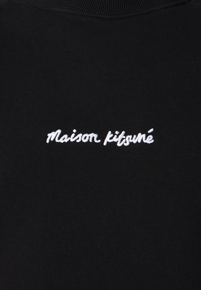 Černá tkanina s bílým kurzívním výšivkovým nápisem "Maison kitsuné" umístěným uprostřed pod výstřihem.