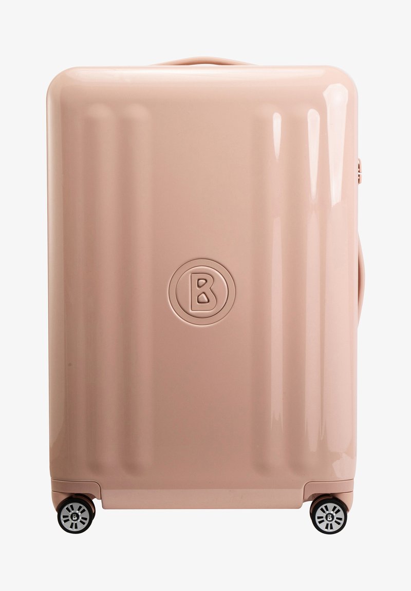 Kovček trde jakosti v svetlo roza barvi, ki ima gladko površino, vertikalne utore, zgornji ročaj in štiri črne kolesa s krožno zasnovo.