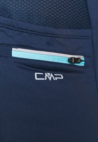Los pantalones deportivos de color azul marino presentan una parte superior de malla texturizada, un bolsillo con cremallera con un acento en azul claro y un logo blanco en el dobladillo.