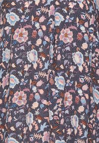 Tessuto navy con un denso motivo floreale in rosa pastello, blu e marrone, che presenta grandi fiori, piccoli boccioli, foglie e pois bianchi.