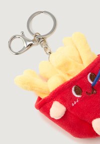 Plush keychain shaped like a red container of French fries with yellow fries, embroidered eyes, and nose, attached to a metal key ring.
