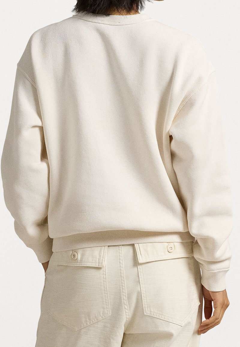 Sudadera de mezcla de algodón en beige claro con puños y dobladillo acanalados, que presenta un corte relajado y costuras en los hombros para mayor comodidad.