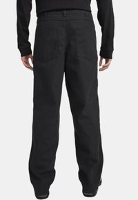 Mustat cargo-housut rentoa istuvuutta varten, joissa on kaksi takataskua ja yksi sivutasku, valmistettu kestävästä kankaasta, jolla on sileä tekstuuri.