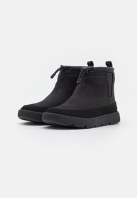 Schwarze Ankelschuhe aus Wildleder und synthetischem Material, mit glatter Textur, runder Spitze und elastischen Schnürsenkeln für einen sicheren Sitz.