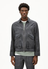 Dunkelgraue Jacke aus weichem Stoff, mit einem Reißverschluss vorne, zwei frontalen Taschen und einem lässigen Design mit Kragen.