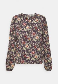 Blouse florale avec manches longues, un col rond, et un fond violet foncé orné de motifs floraux verts clairs, roses et jaunes.