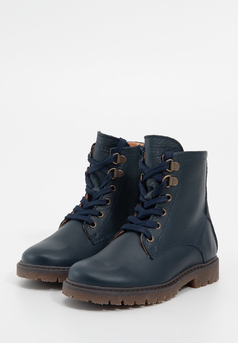 Dunkelblaue Leder-Stiefeletten mit runder Zehenpartie, dunkelblauen Schnürsenkeln und brauner strukturiertem Gummisohle. Mit Metallösen und braunem Innenfutter.