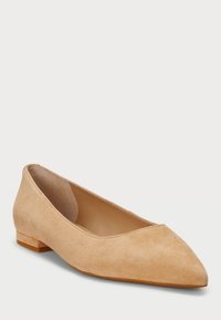 Ballet flat em camurça bege com bico puntiagudo e salto baixo. Textura suave e design minimalista, sem hardware ou detalhes visíveis.