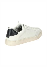 White leather sneaker with a navy heel accent. Features a low-top design, round toe, flat rubber sole, and lace-up front. Textured stitching visible.