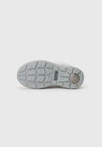 Suela de goma gris con patrón de textura, marcada con "PRIMIGI," que cuenta con un detalle circular de absorción de impactos.