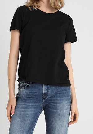 Sort bomuld T-shirt med korte ærmer og rund hals, vist uden at være stoppet ned over lyseblå denimjeans. Ingen synlige mønstre eller detaljer.