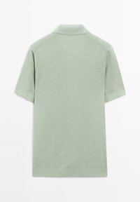 Polo a maniche corte di colore verde chiaro, realizzato in tessuto a maglia testurizzata. Presenta un colletto classico e polsini a costine con orlo dritto.