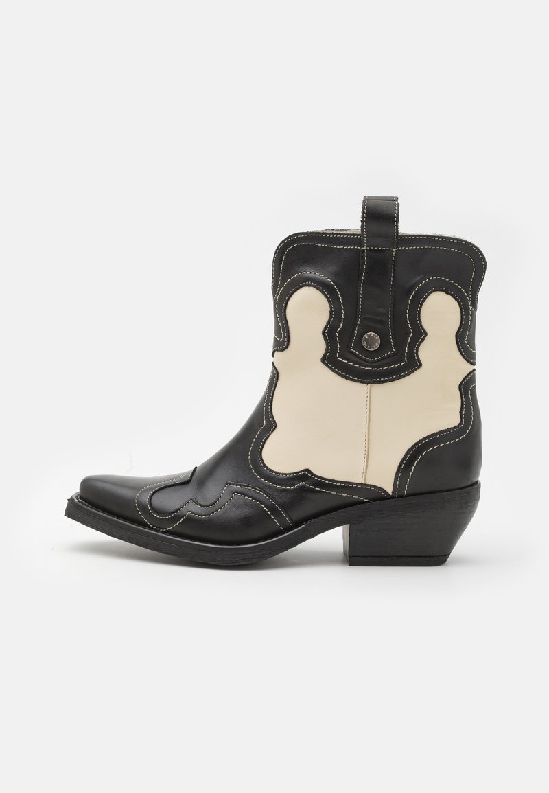 Black and cream leather cowboy boot with white stitching, pointed toe, curved patterns, and a short stacked heel. Pull tab on the back.