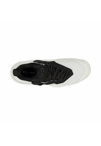 Scarpa sportiva in bianco e nero con tomaia testurizzata, linguetta imbottita e lacci. Presenta un design aerodinamico e una suola in gomma con modelli di grip.