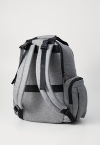 Γκρι σακίδιο υφάσματος με μαύρες λεπτομέρειες, ρυθμιζόμενους ιμάντες, πλαϊνή τσέπη και λαβή στην κορυφή. Διαθέτει υφή και ανθεκτικούς φερμουάρ.