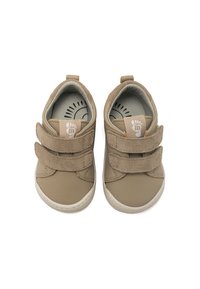 Scarpe per bambini di colore beige, realizzate in pelle e suede, caratterizzate da due cinturini in velcro, una punta arrotondata e una suola texturizzata con un leggero accentuamento al tallone.