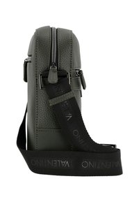 Sac bandoulière en cuir vert texturé avec fermeture éclair, sangle noire réglable portant la marque "VALENTINO" et forme rectangulaire.