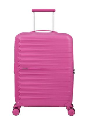 Valigia rigida di colore rosa brillante con manico telescopico e quattro ruote girevoli, texture a rilievo orizzontale sulla superficie frontale.