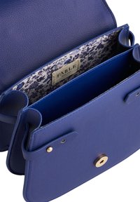 Blue leather handbag featuring a textured exterior, gold hardware, and a floral patterned interior lining. Includes multiple compartments.