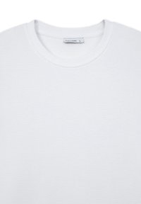 T-shirt bianca in cotone con texture a coste, design a girocollo e un'etichetta interna che indica la taglia grande del marchio Calliope.