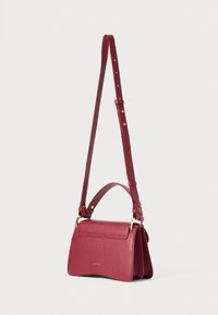 Geantă roșie din piele, tip crossbody, cu un design structurat, având un mâner superior, curea reglabile și accente din metal auriu.