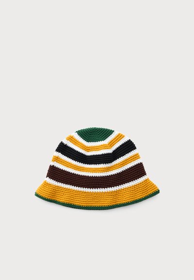 Crocheted bucket hat with wide brim featuring horizontal stripes in green, yellow, black, brown, and white on a light gray background.